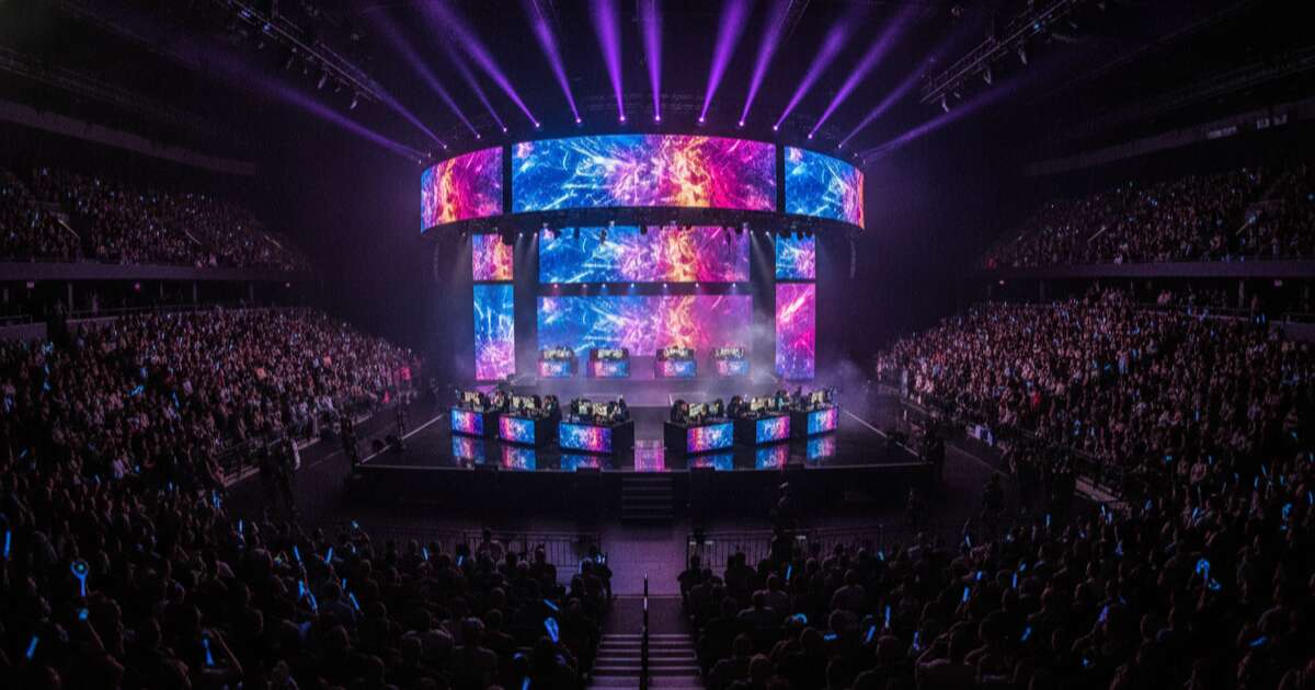 Arena de esports com telas grandes e publico assistindo um torneio de gaming