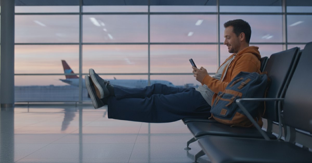 Traveler reviewing words on a phone while waiting at an airport gate