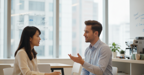 Two colleagues practicing English conversation at an office