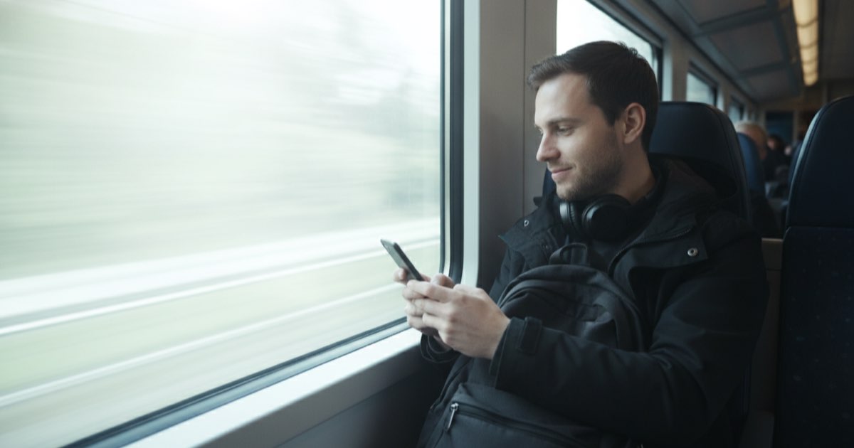 Estudante praticando vocabulário em inglês sozinho no celular durante o trajeto matinal